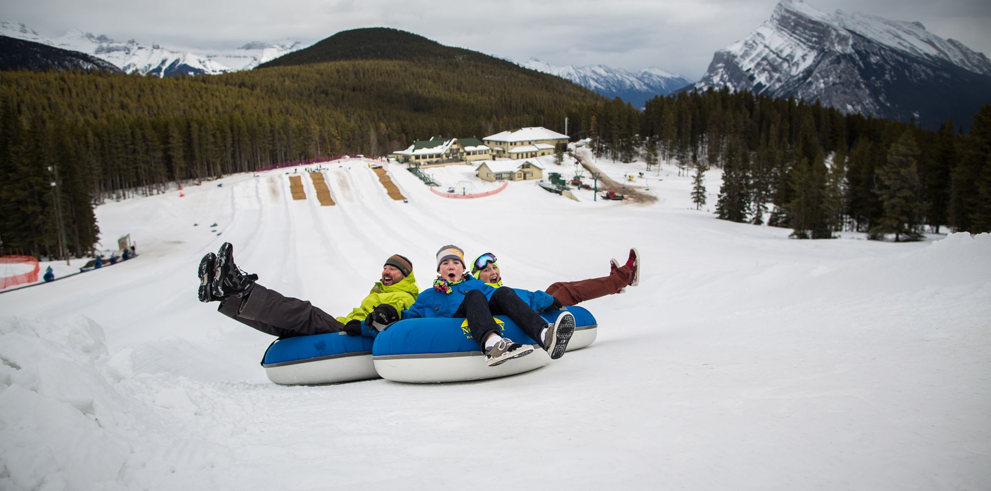 A family tubes on the snowy slopes of Banff and Lake Louise, AB