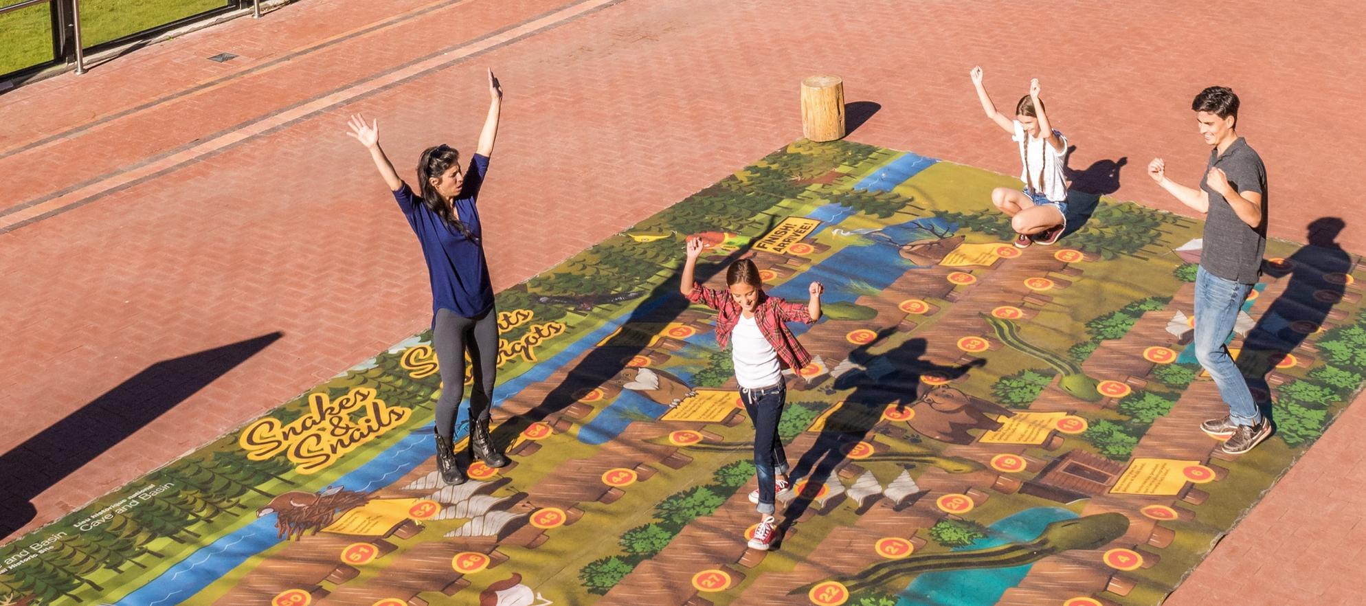 Family having fun playing a giant board game.