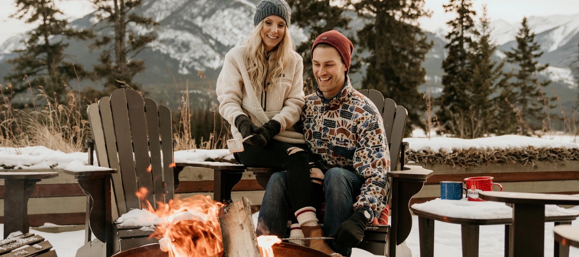 A couple enjoy smores by the fire on the Juniper Bistro patio