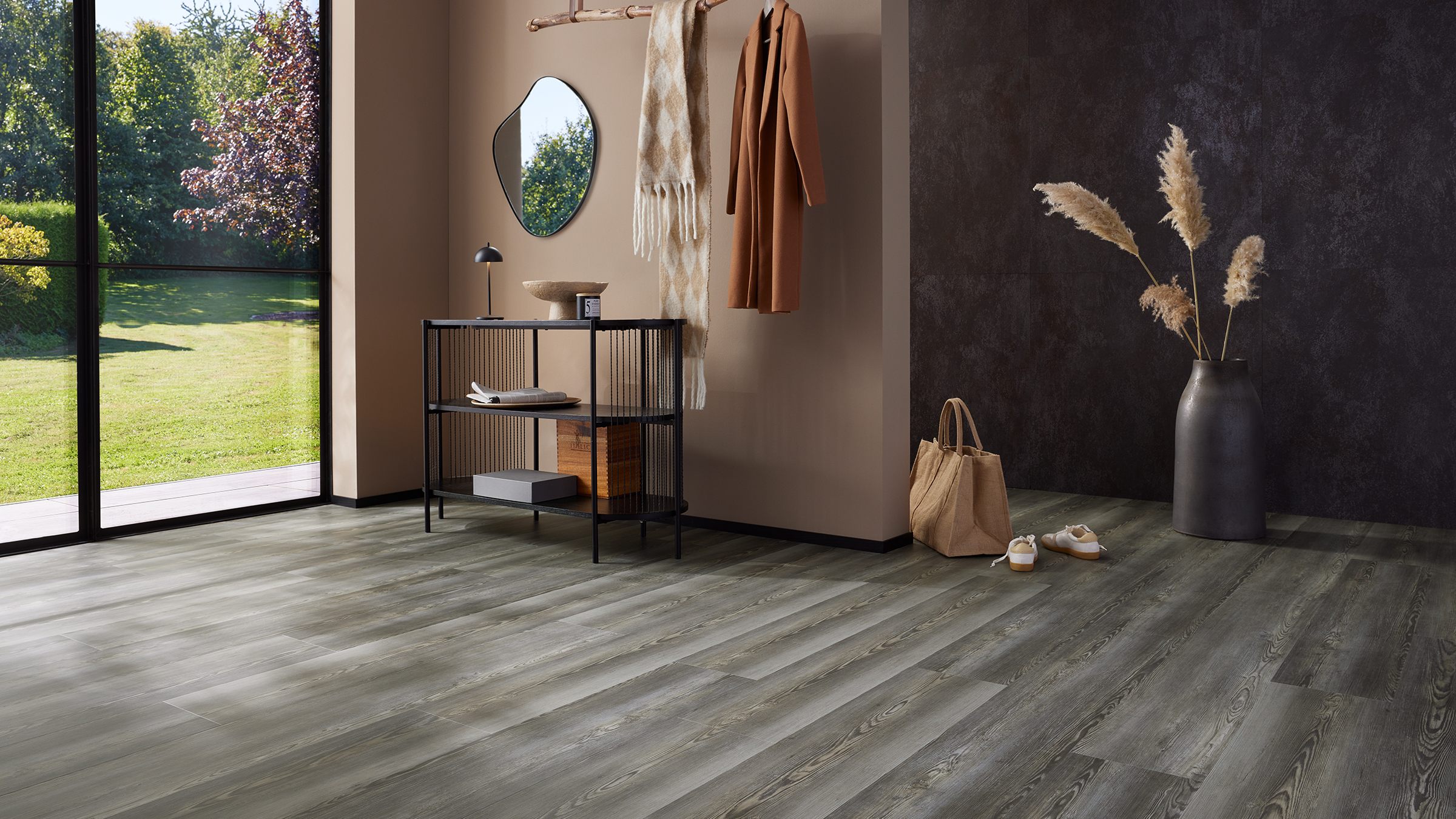 Garderobe in erdigen Tönen mit einem gräulichen Holzboden und reduzierter Deko