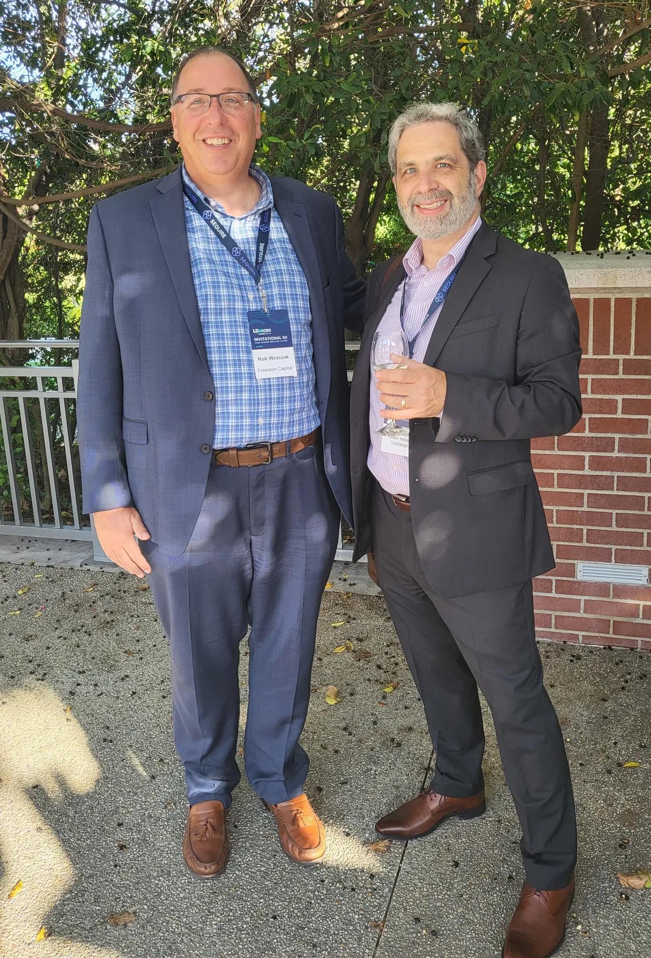 Two men in suits, GIX CEO Daniel Labovitz and board member Rob Wotczak, smiling at the camera outdoors