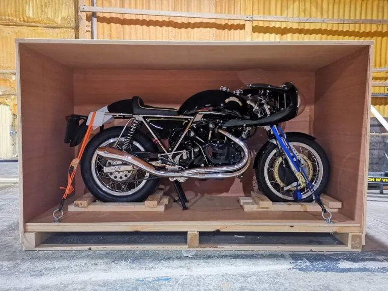 Motorcycle strapped and braced inside an open wooden crate