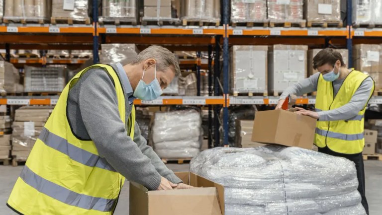 Warehouse worker packing parcels for dispatch