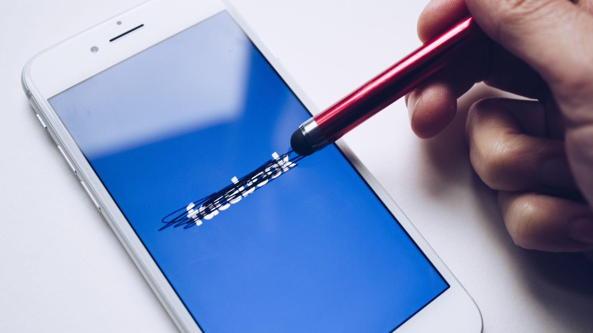 Bilde av en mobiltelefon med Facebook logo som er overstrøket