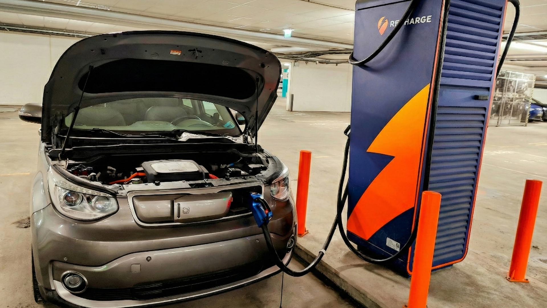 Kia Soul EV med panseret åpnet står og lader ved en hurtiglader