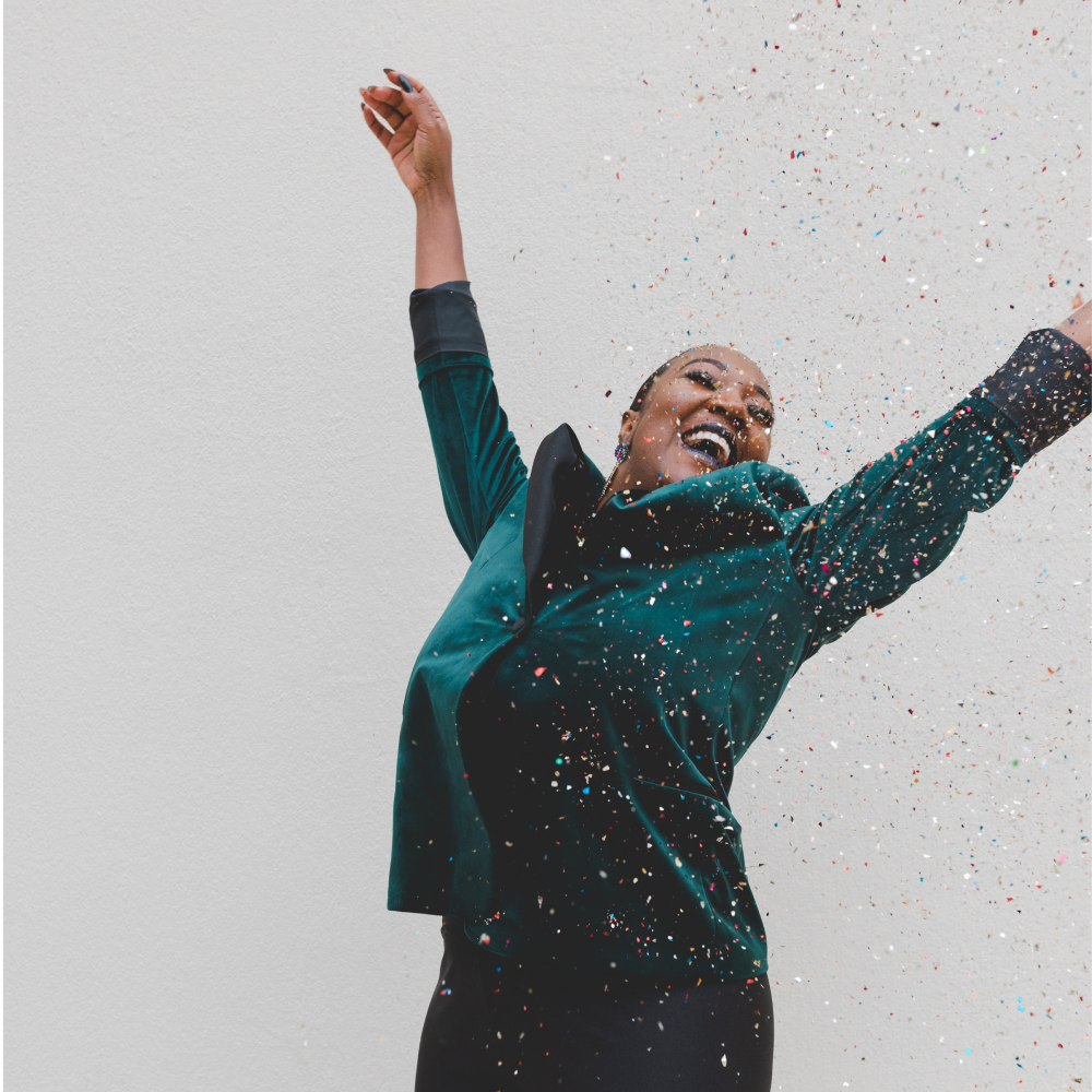 Smiling woman throws hands in the air