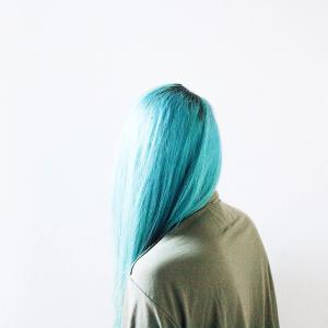 Teal haired woman wearing a brown top