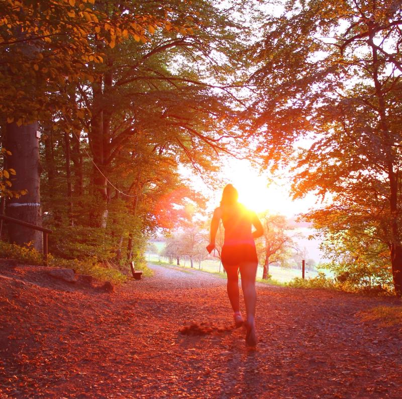 Woman running through woodland