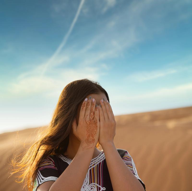 Woman hides behind hands