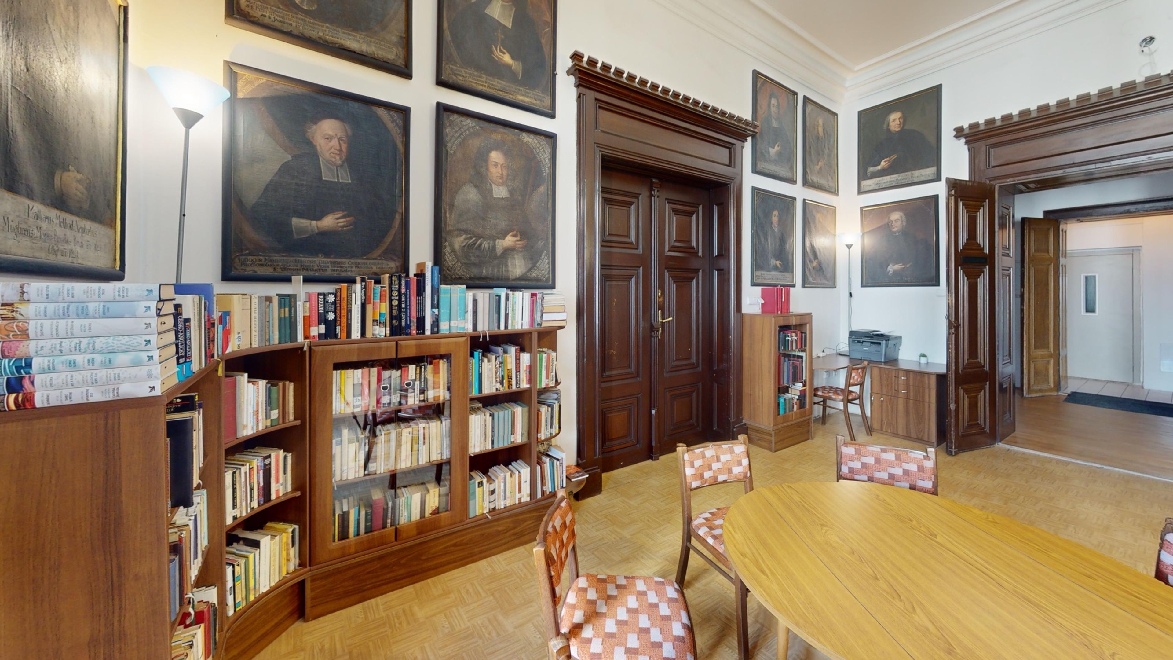 Knihovna s regály knih a galerií historických portrétů