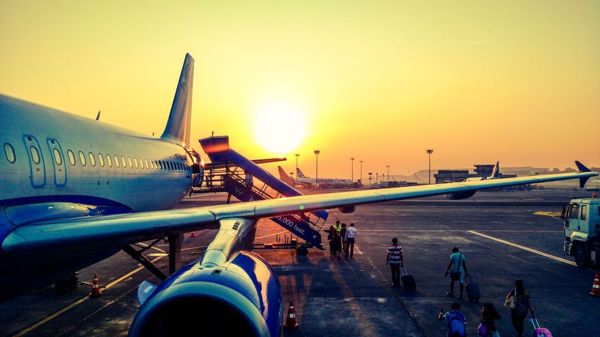 A vibrant image of passengers boarding an airplane at sunrise.