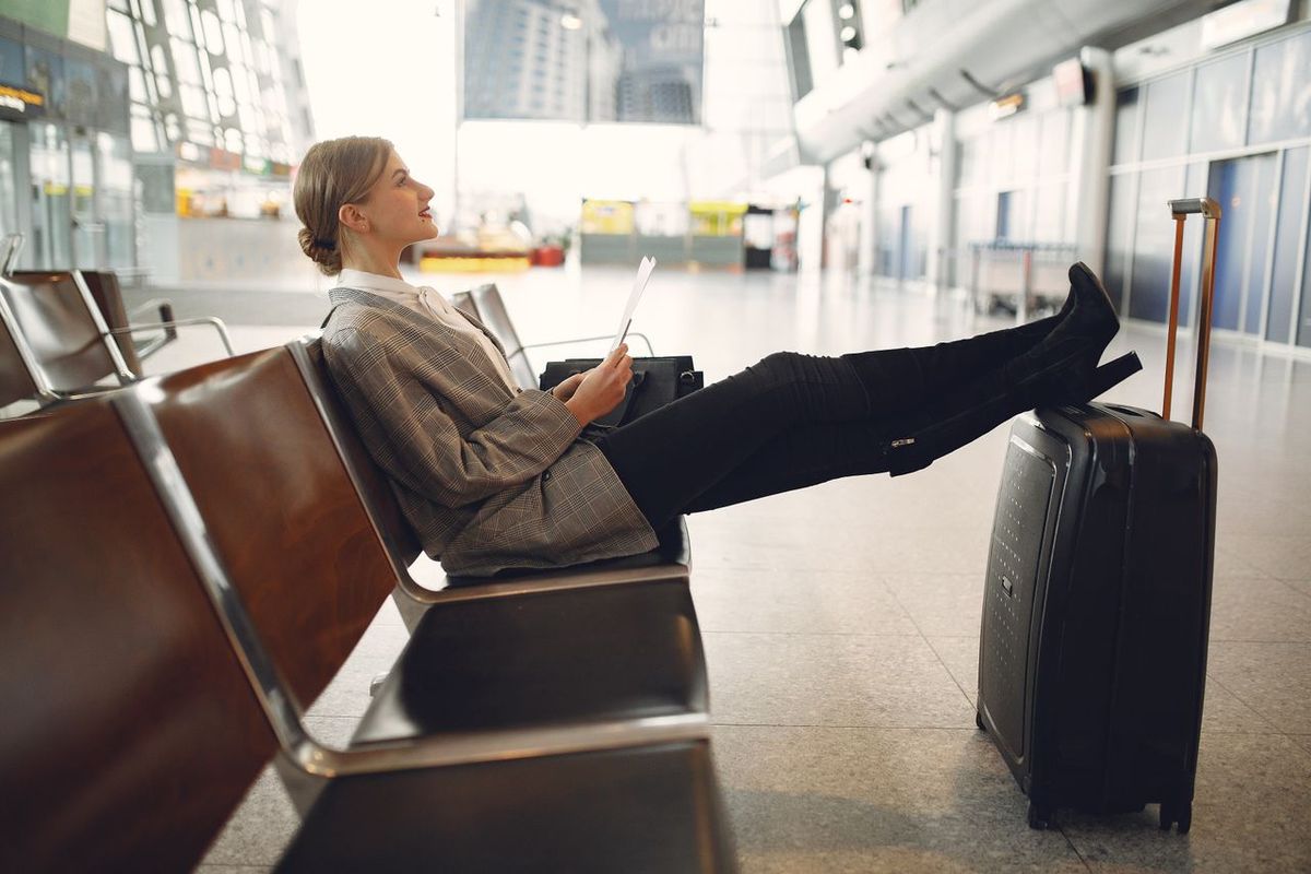 Traveler resting at airport with suitcase.