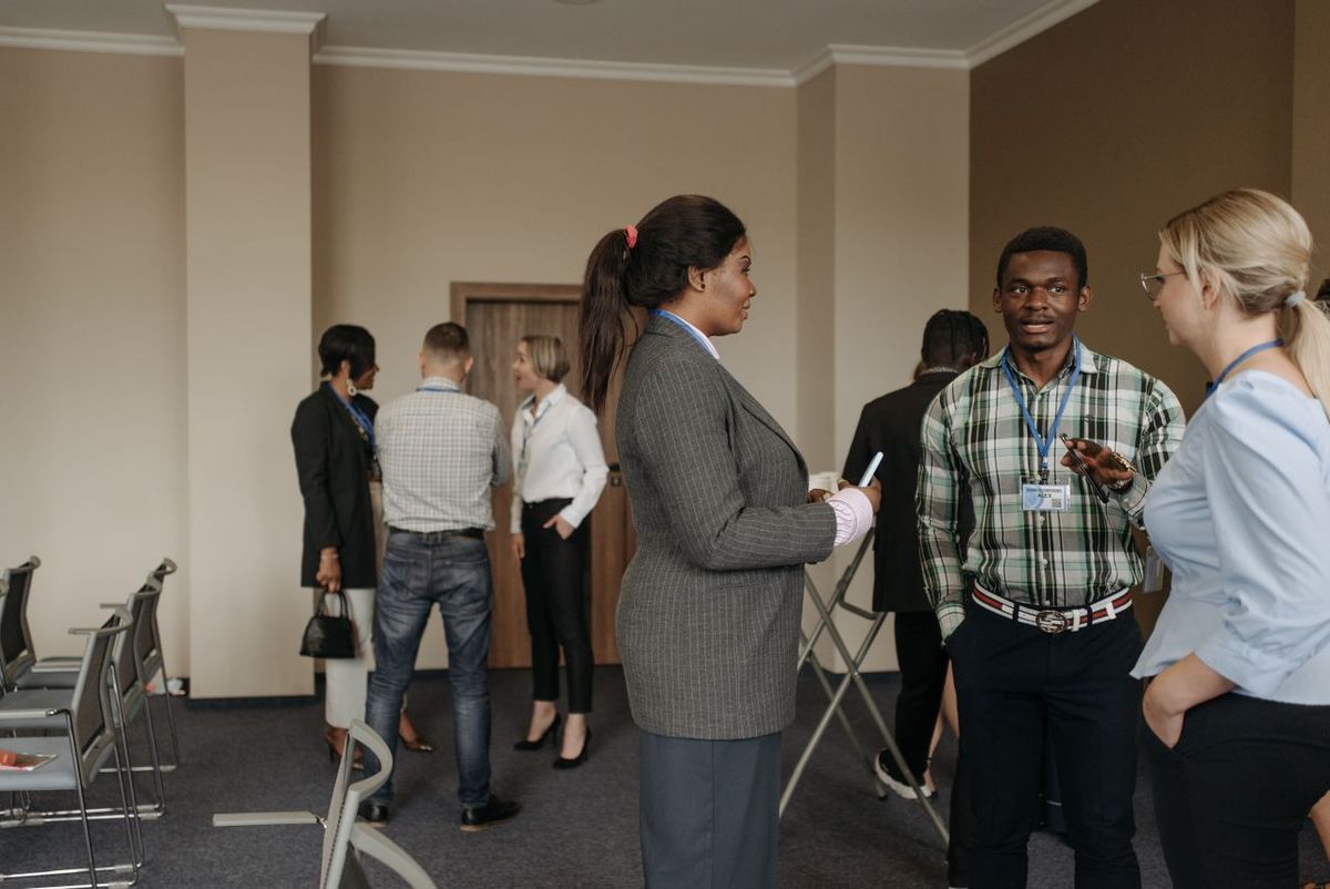 Conference attendees networking and chatting in a meeting room.