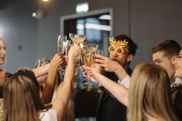 Joyful group of diverse adults toasting with champagne at a lively indoor party.