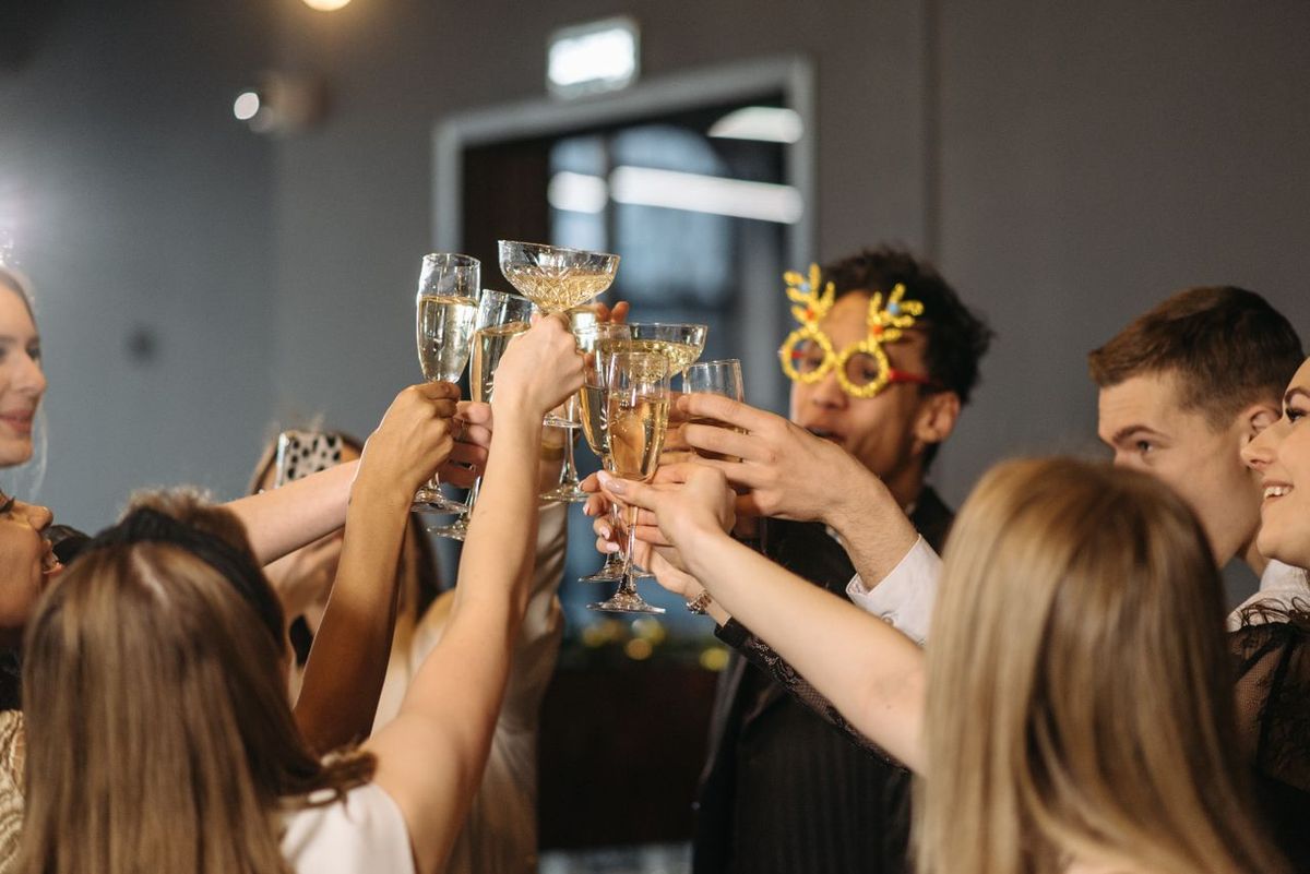 Joyful group of diverse adults toasting with champagne at a lively indoor party.