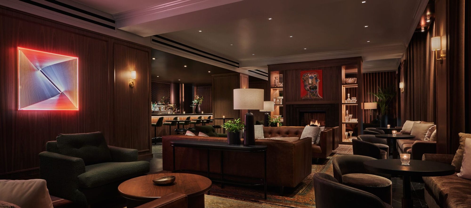The lounge at Bar Pendry: warm low lighting, leather seating, and a fireplace