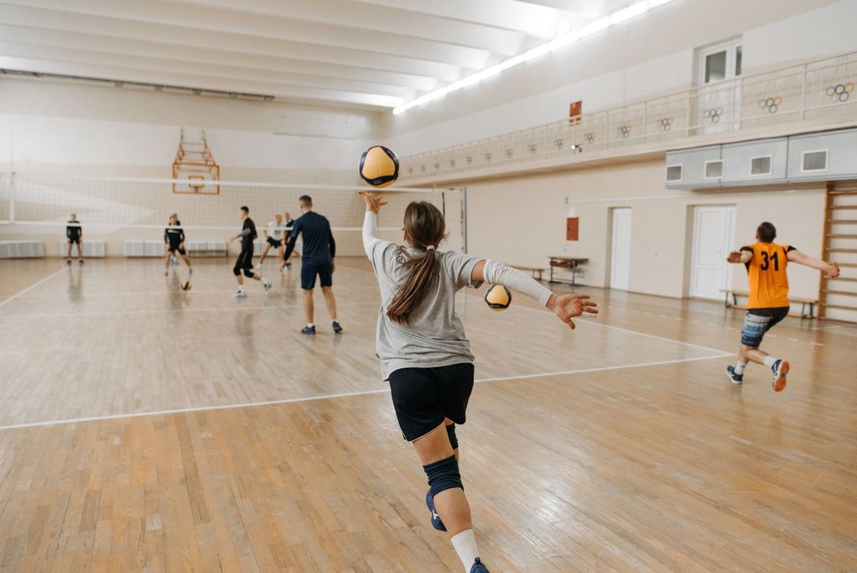 Volleyball players practicing on an indoor court.