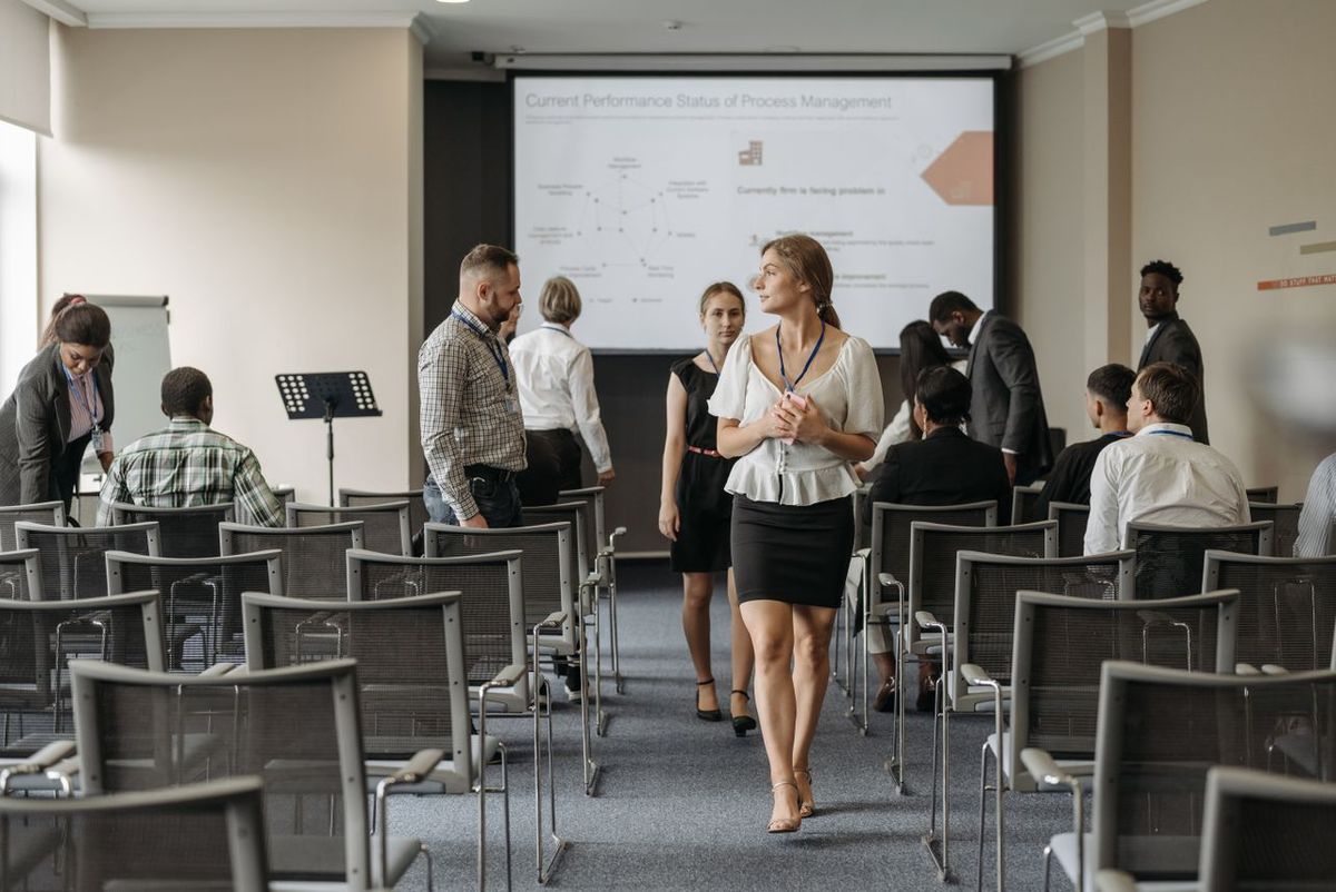 Business seminar room with people and presentation screen.