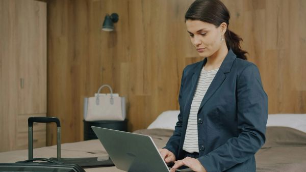 Woman using laptop in hotel room