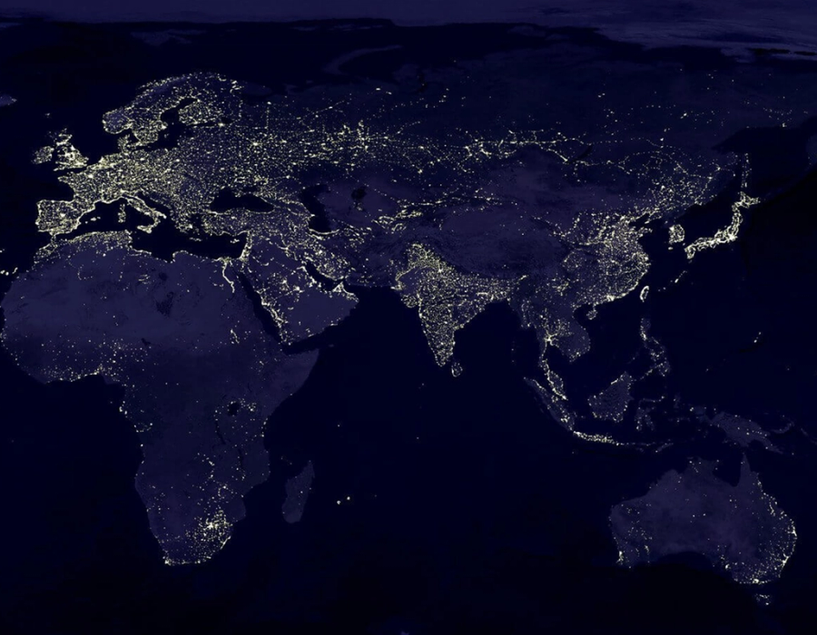 Stylised image of the globe at night with pinpricks of light dotted throughout major cities