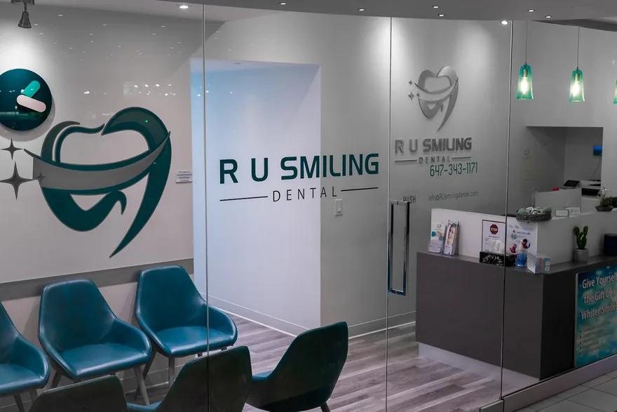 The clinic entrance: glass doors under the R U Smiling Dental sign, with the reception desk and waiting chairs beyond