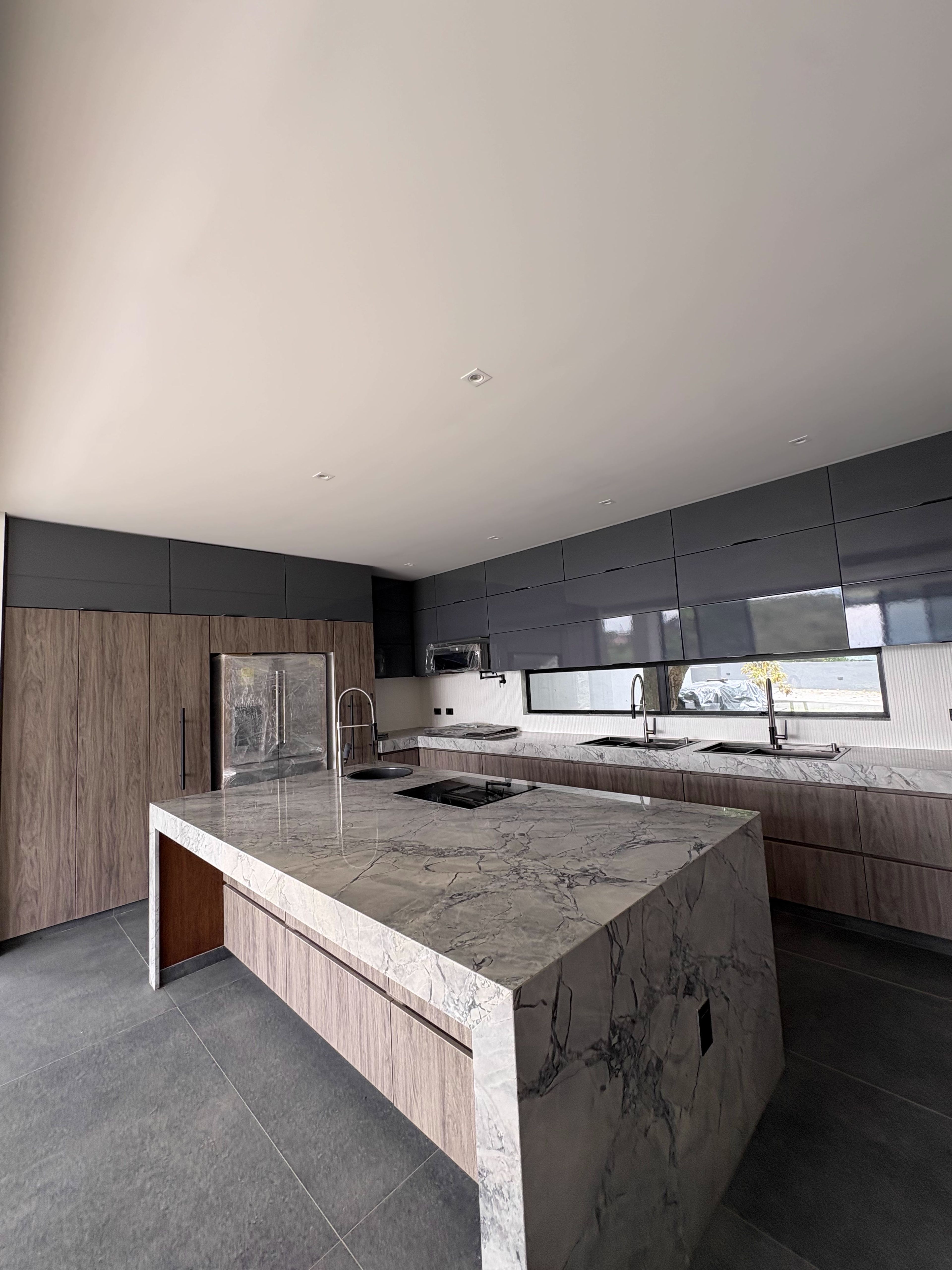 Cocina con isla en mármol y gabinetes de madera