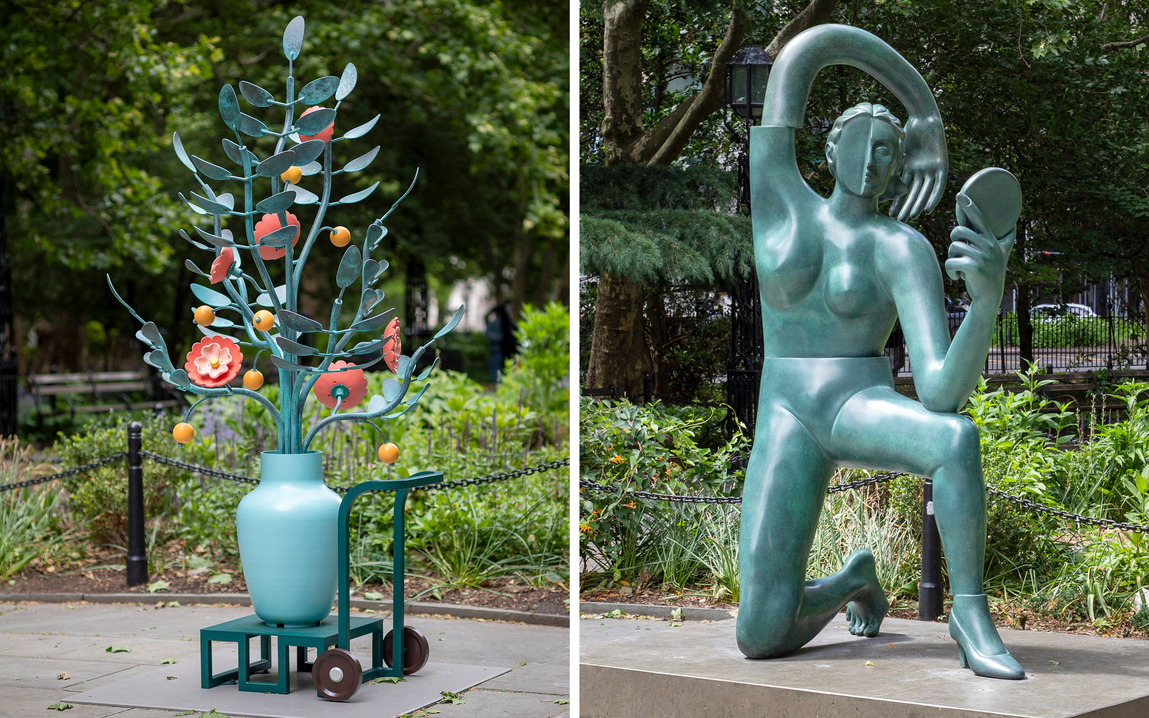 A large outdoor sculpture of a pale blue vase on a wheeled cart, holding oversized metal branches with coral flowers and yellow spheres, installed in a public park.; A large green patinated bronze sculpture of a stylized kneeling female figure holding a hand mirror, with her arm arching over her head, installed in a public park.