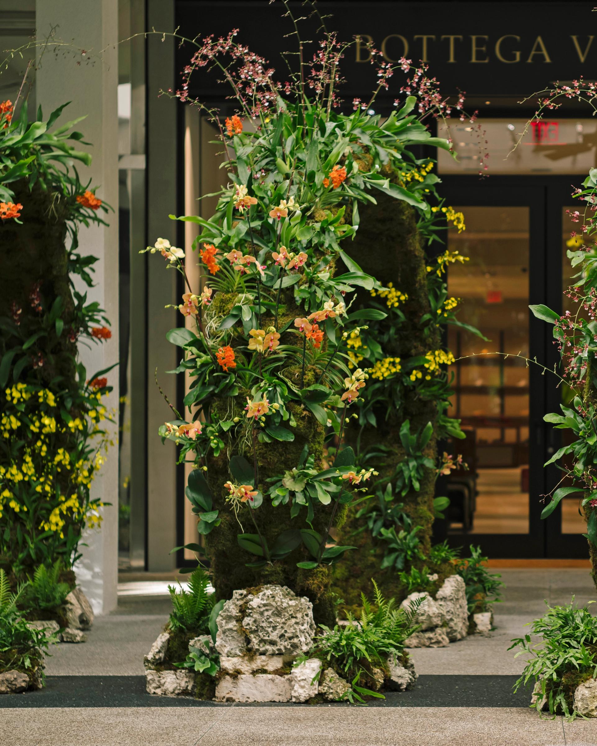 A side view of a ring of flowers in a shopping space.