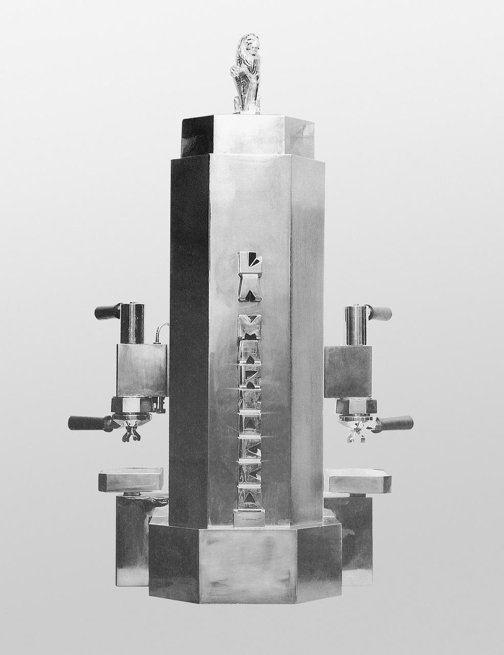 Archival photo of coffee machine bearing La Marzocco logo with portafilters on opposite sides and lion statuette on top.