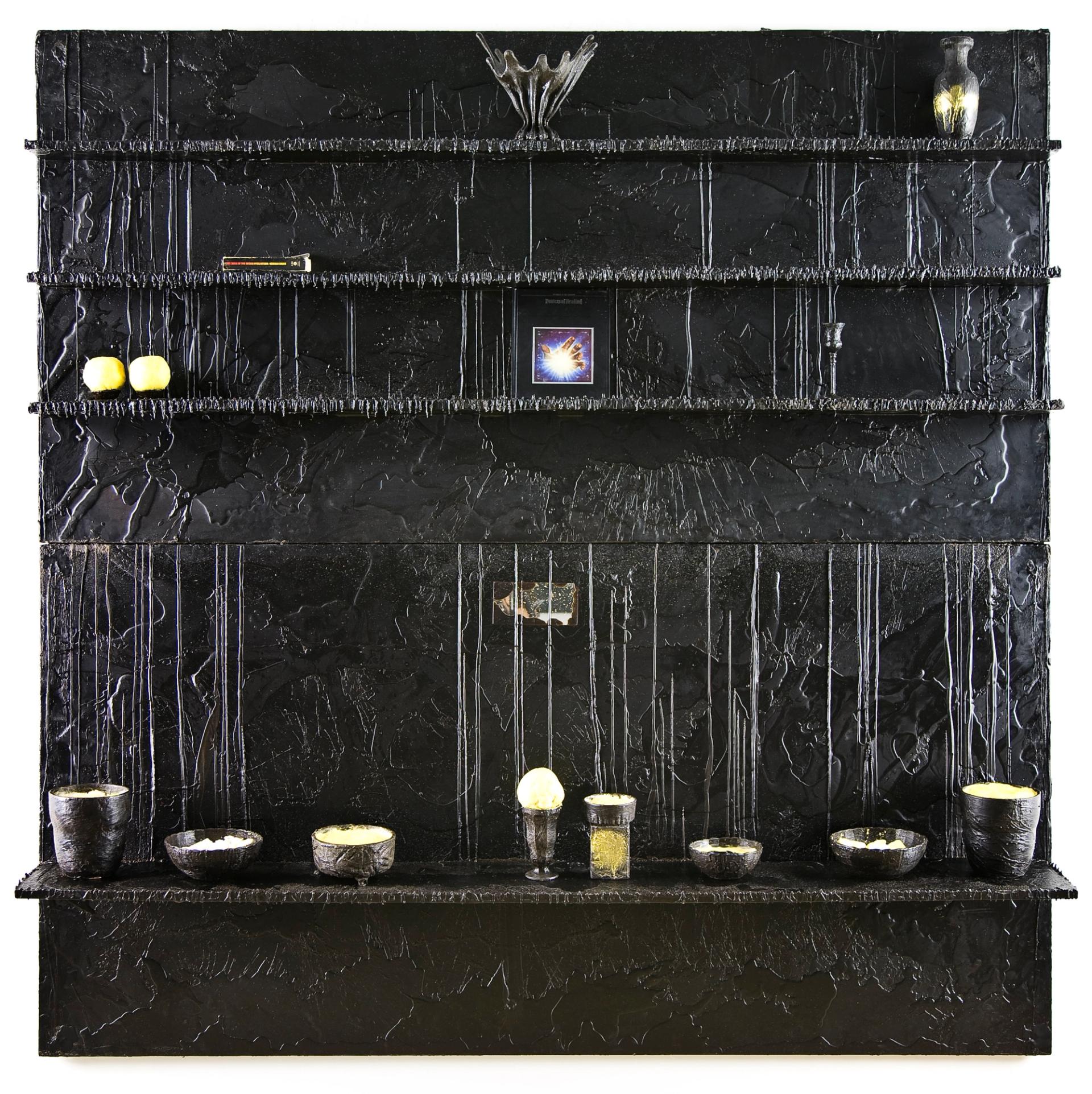 Black wax-coated shelving installation displaying books, vessels, and illuminated objects.