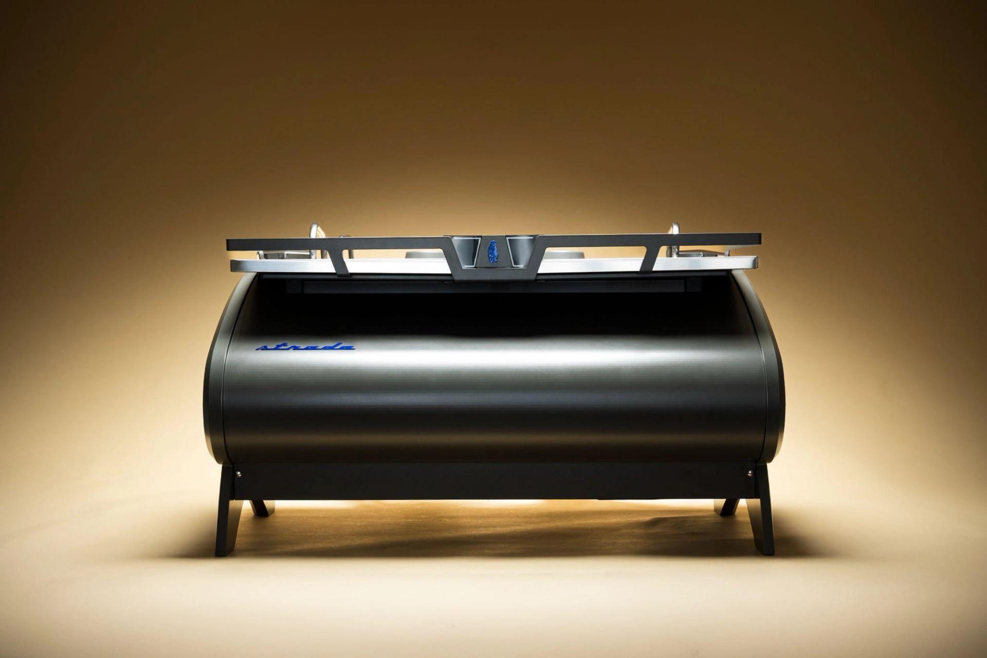 Silver espresso machine displayed against a warm gradient background.
