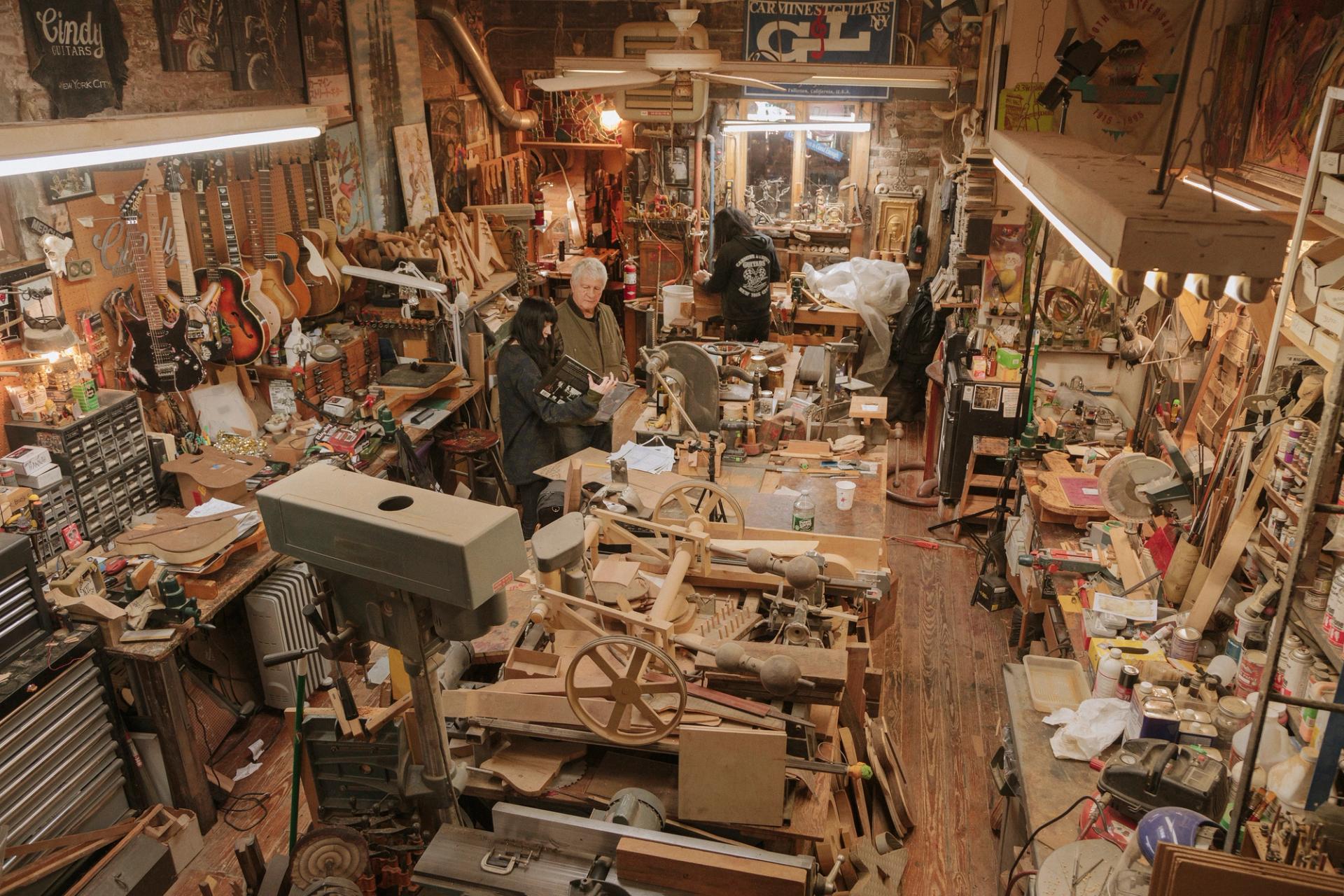 A wide view of a cluttered wood workshop, taken from above