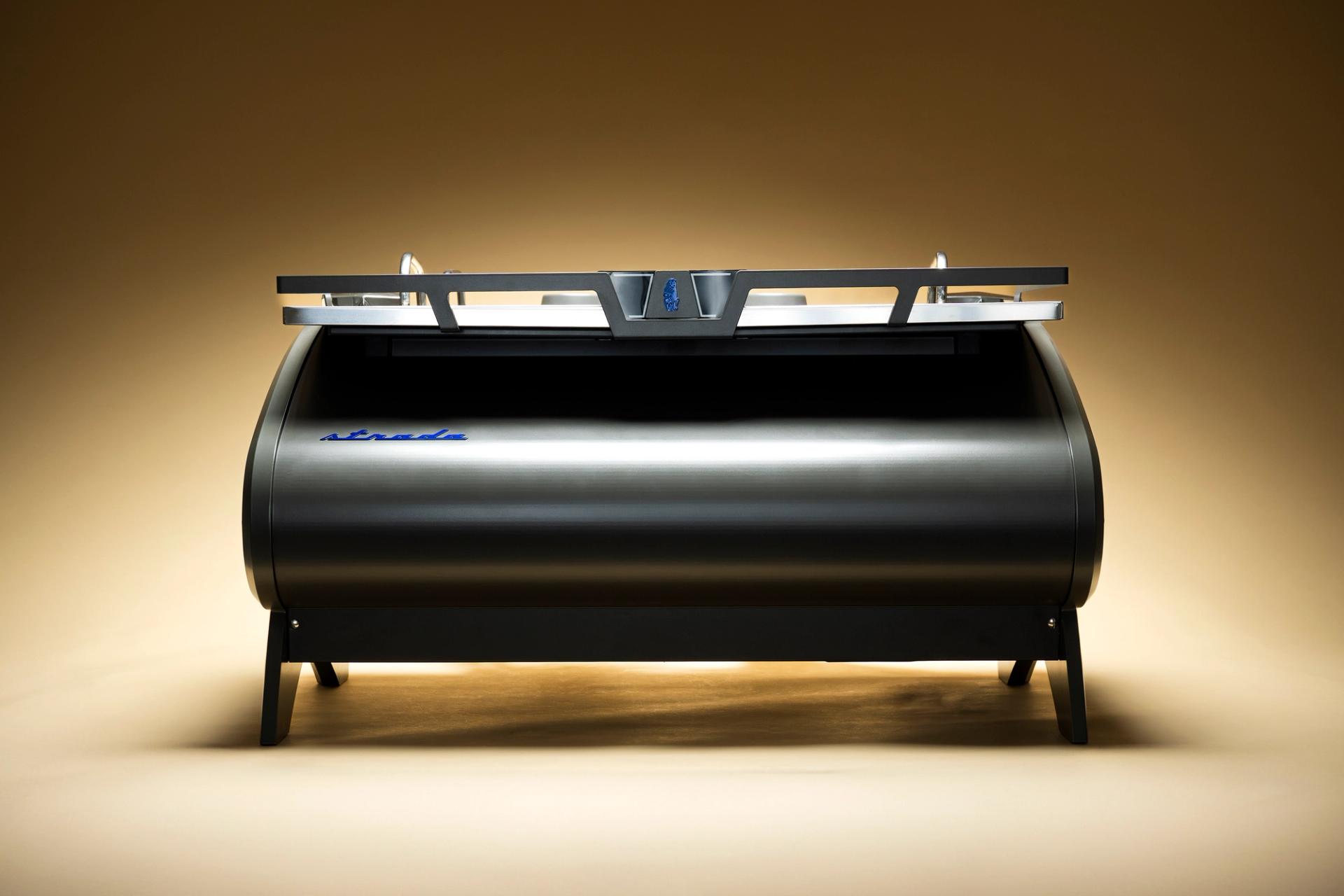 Silver espresso machine displayed against a warm gradient background.