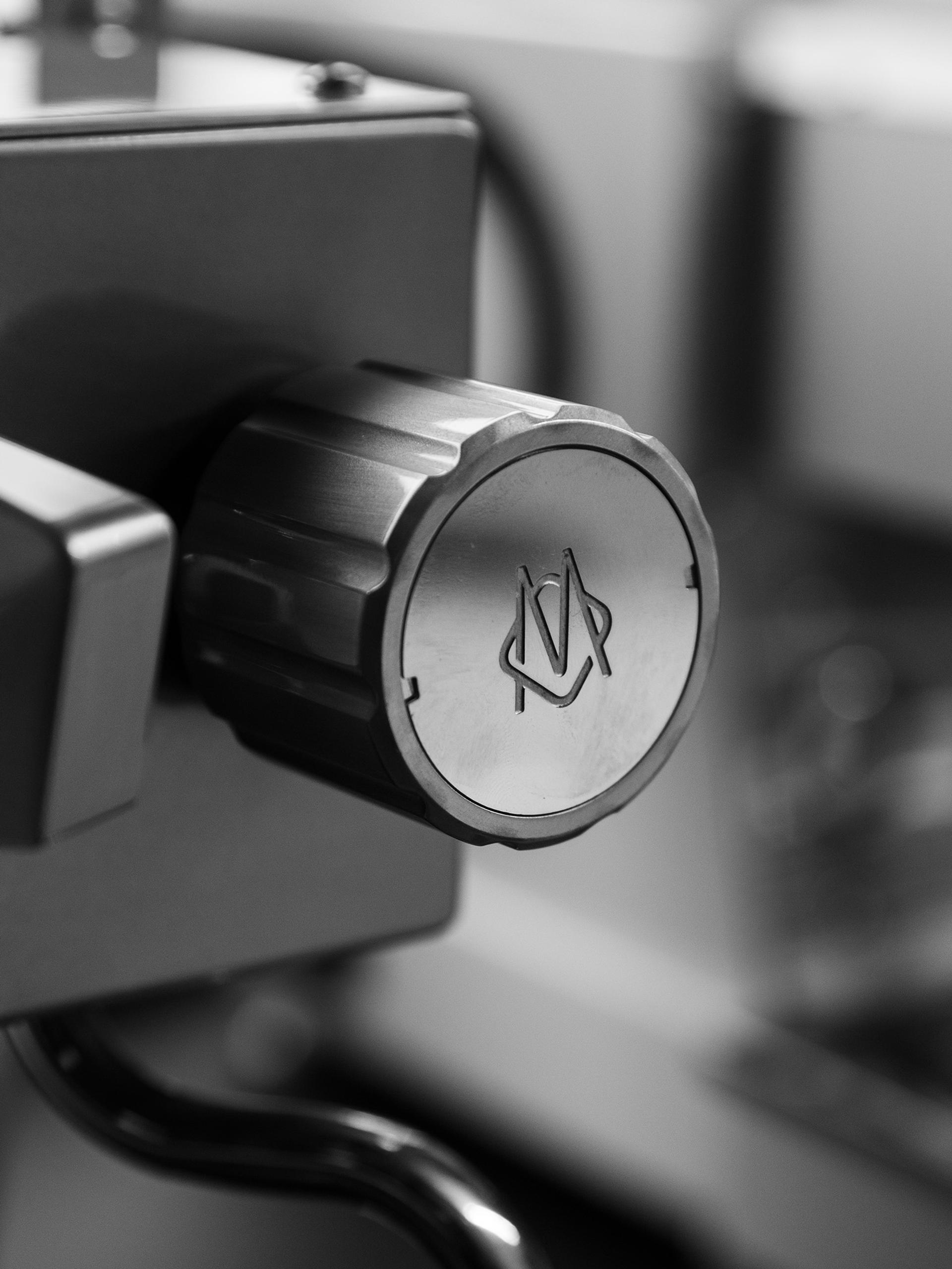Close-up of a knob on an espresso machine bearing the La Marzocco logo.