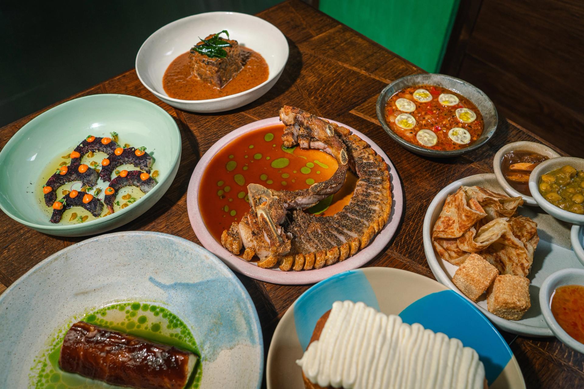 A selection of plated dishes on a wooden tabletop