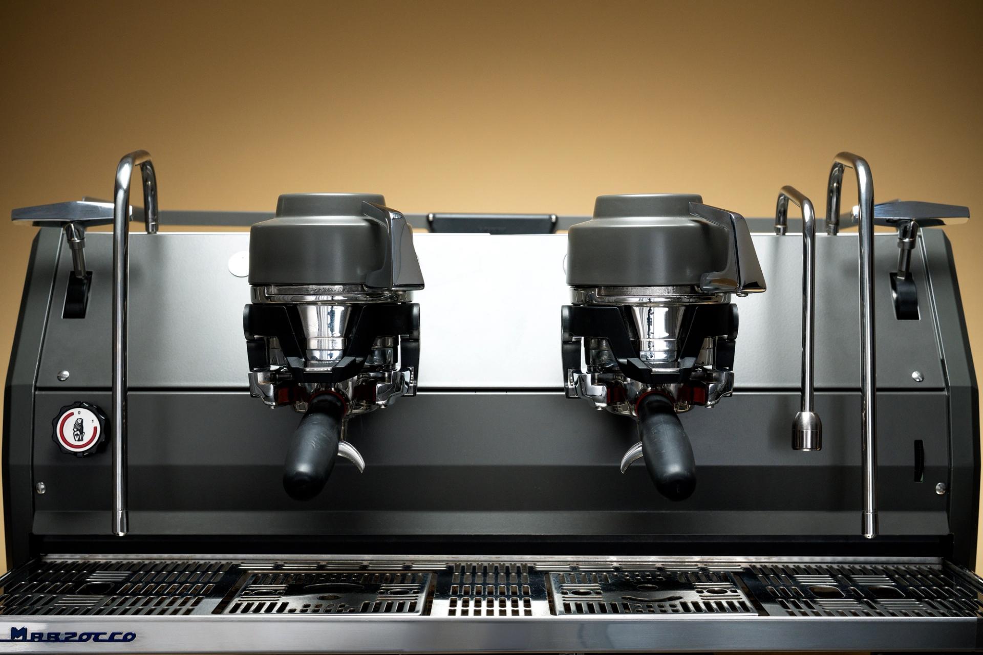 Close-up of filters on an espresso machine against a warm gradient background.