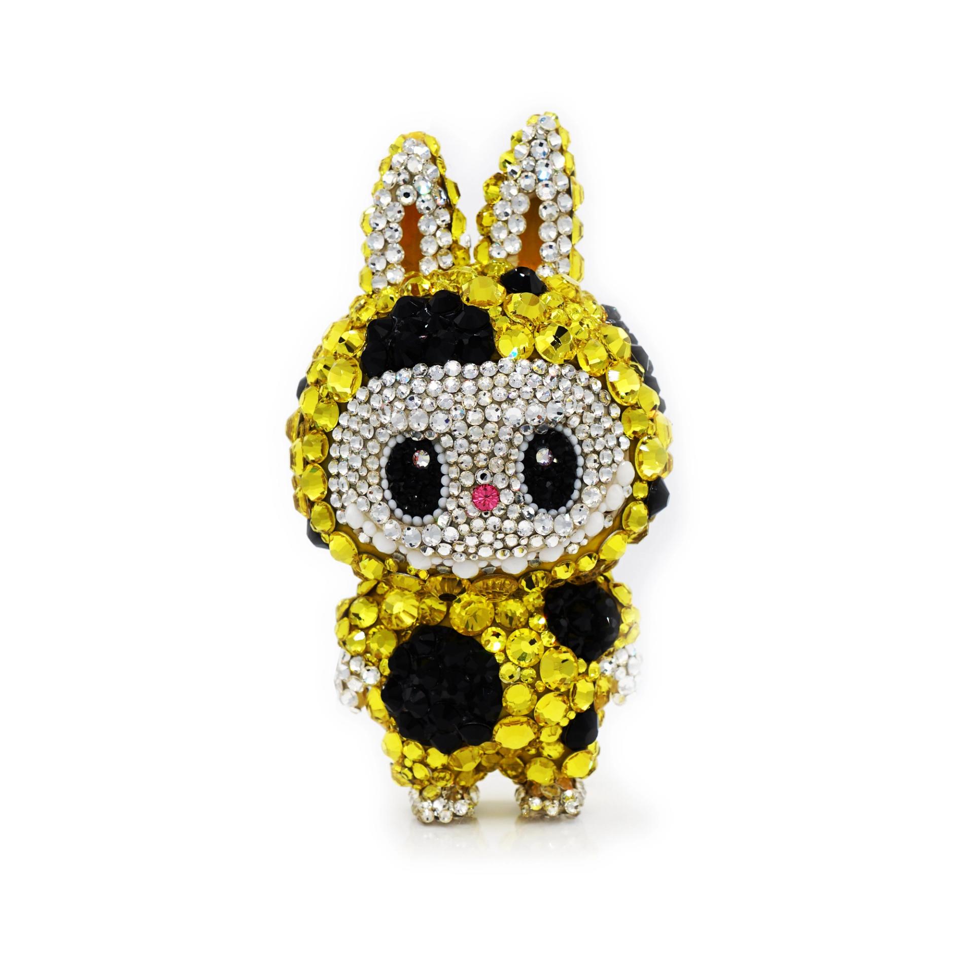 Yellow crystal-covered cartoon rabbit figure with black spots displayed against white background.