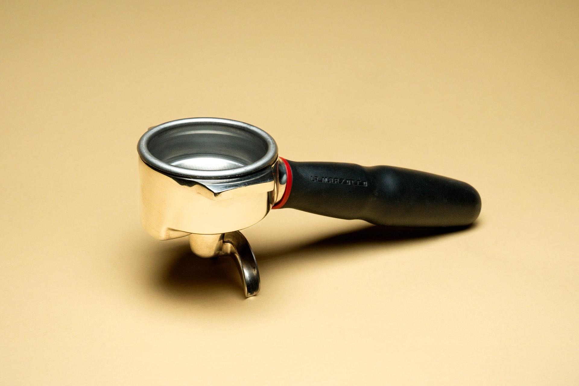 Espresso portafilter displayed against a yellow background.