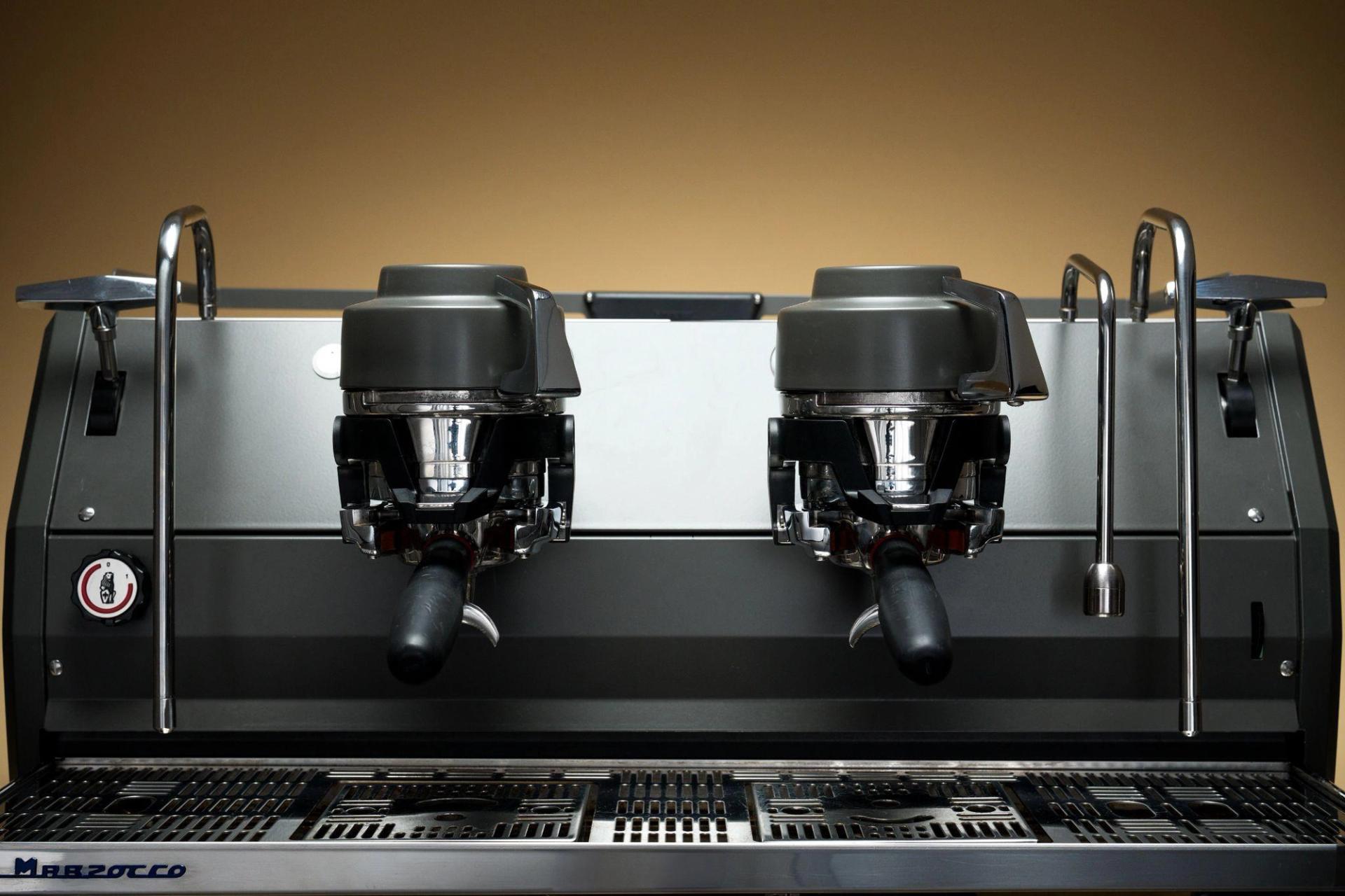 Close-up of filters on an espresso machine against a warm gradient background.