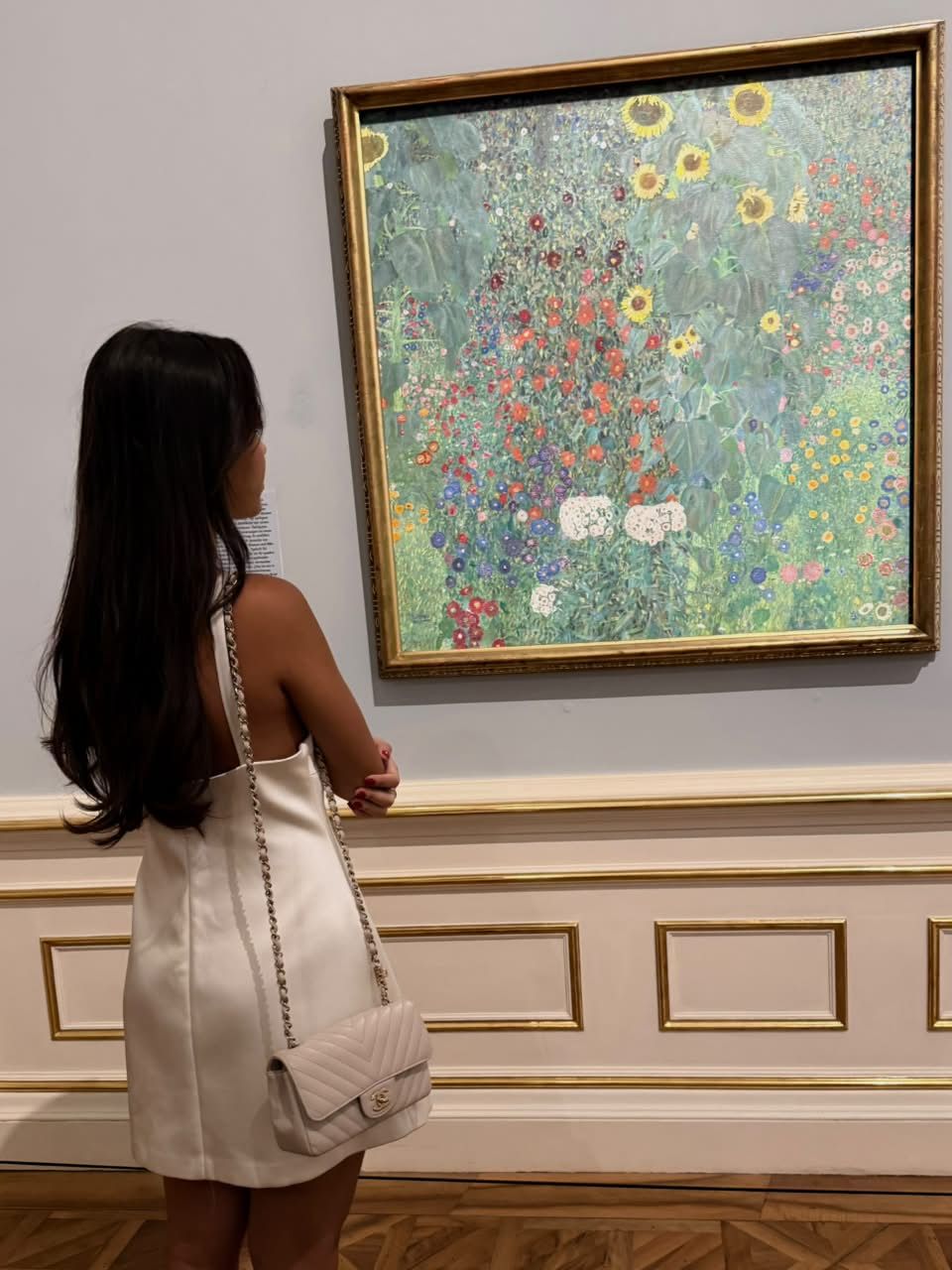 Iasmin observando uma pintura de flores no museu