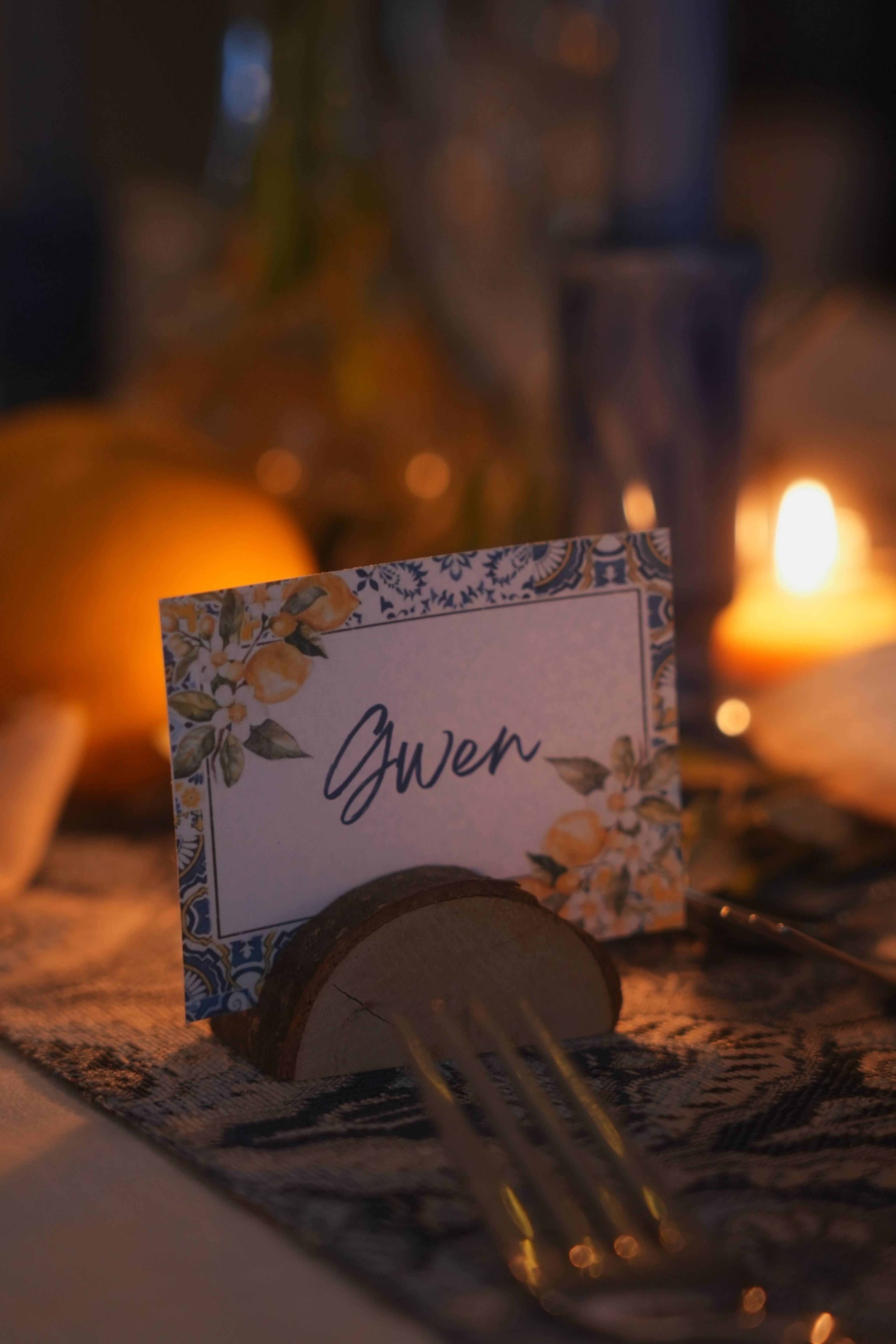 Handwritten name card with painted lemons, candlelight behind