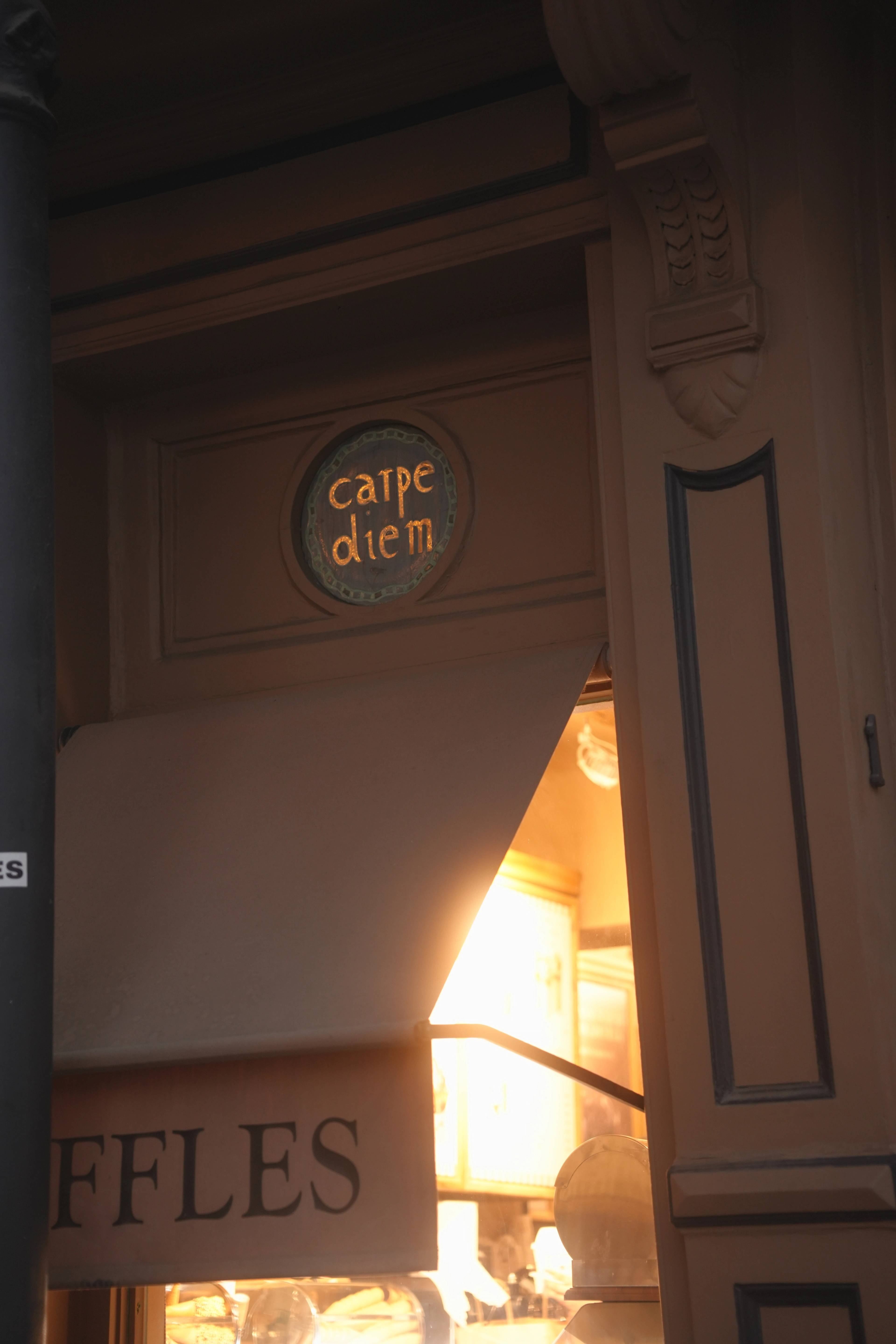 Golden hour on the Carpe Diem bakery door, lettering catching the late sun