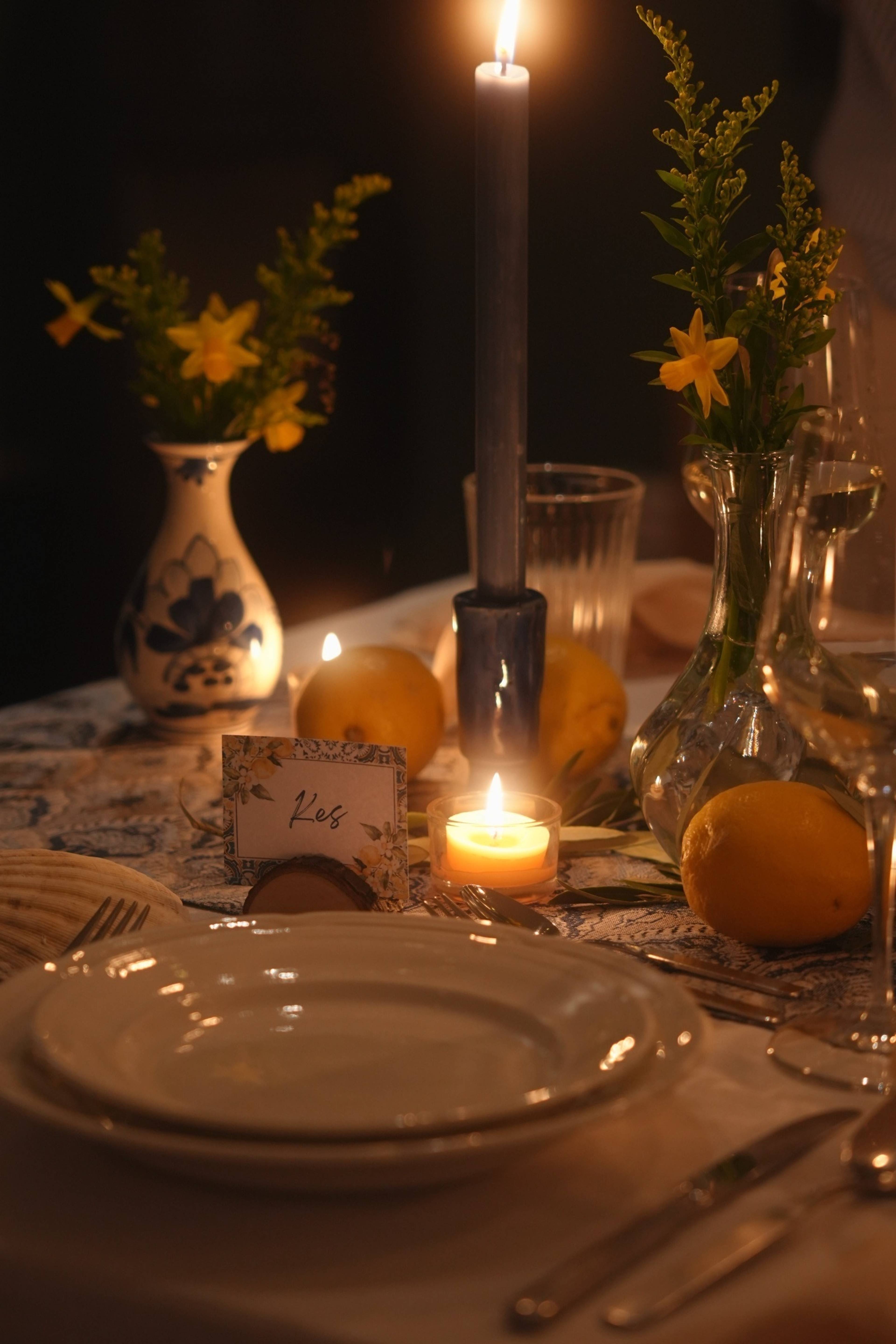 Kes's place setting — name card, painted vase, candle and lemons