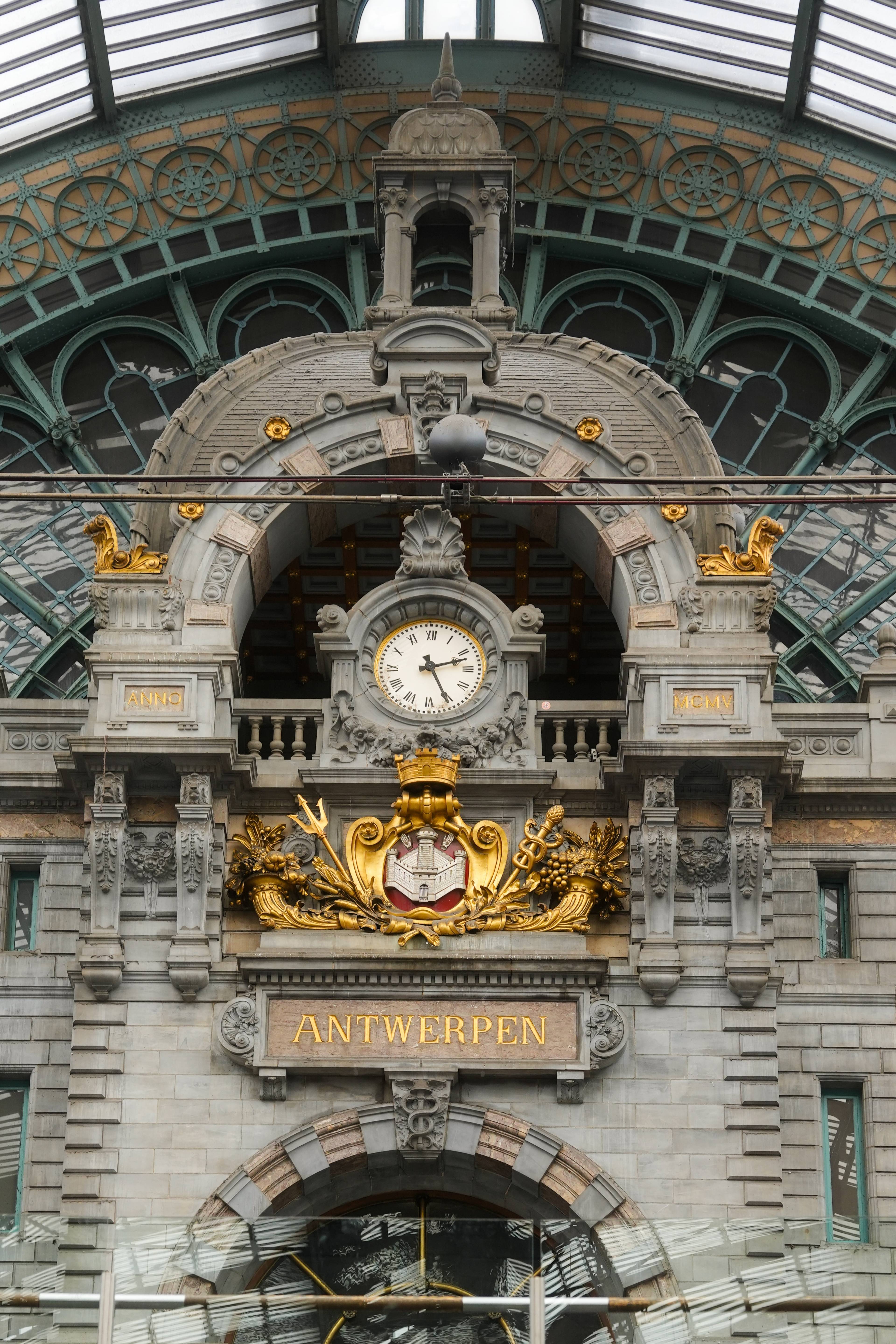 Antwerpen Centraal — clock and gilded crest above the ANTWERPEN sign