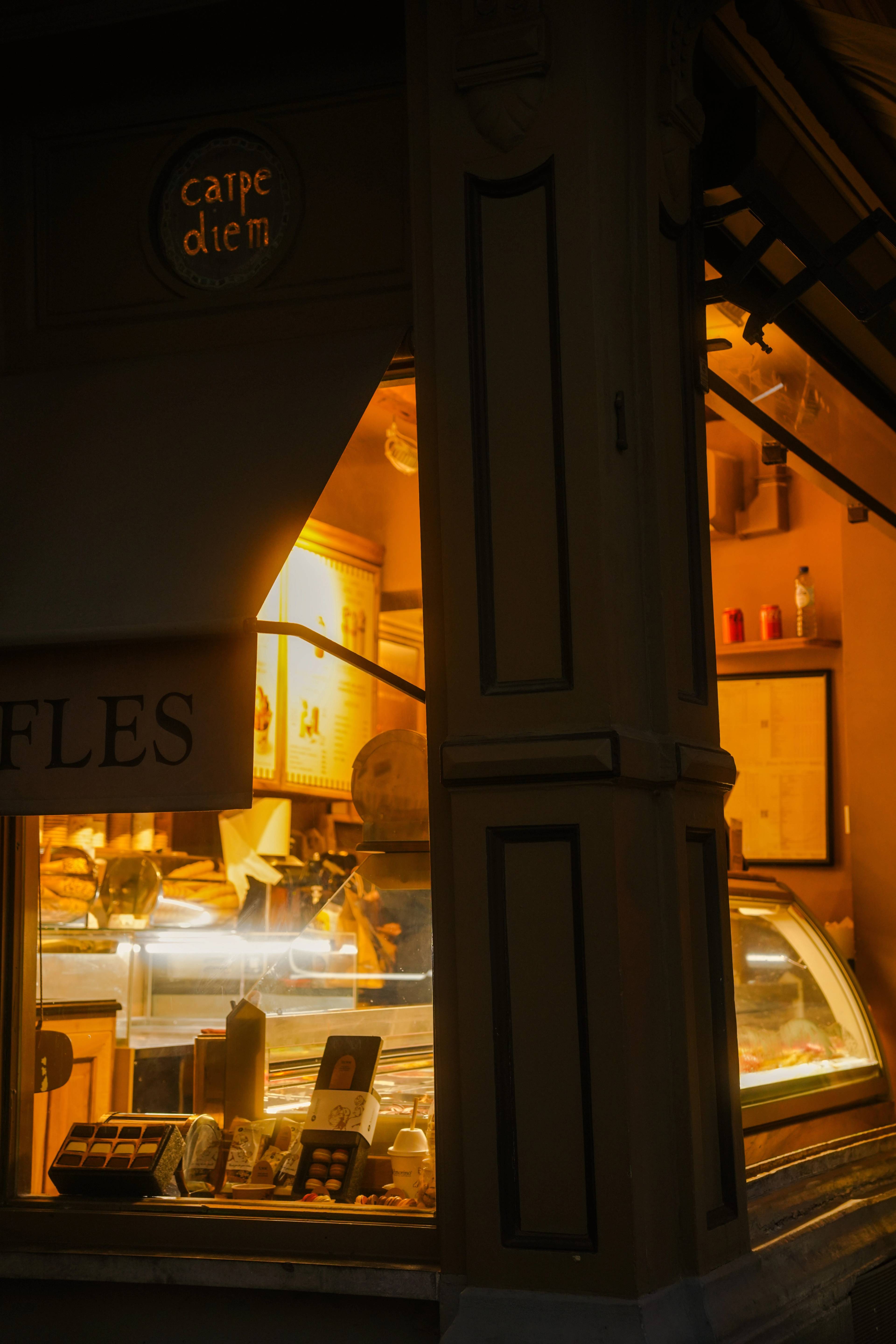 Carpe Diem after dark — warm interior glow spilling onto the cobblestones