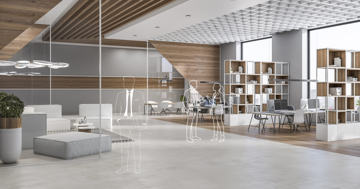 Espace de travail aménagé dans des bureaux en coworking. Y est accolé un espace de détente où des salariés échangent entre eux. Lieu de passage.