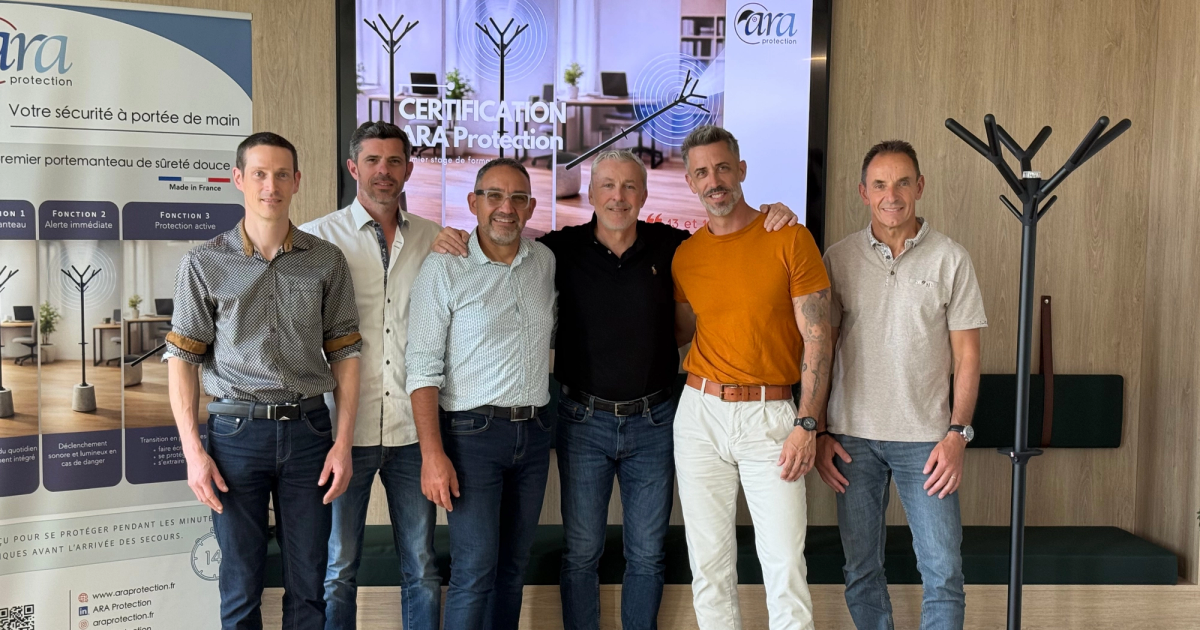 Fin de formation, photo de groupe des 5 stagiaires certifiés posant à côté du portemanteau et du CEO ARA Protection
