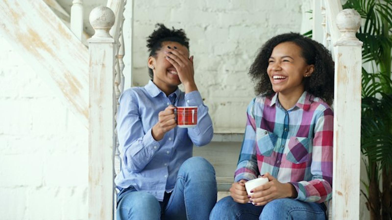 Two friends laughing over coffee