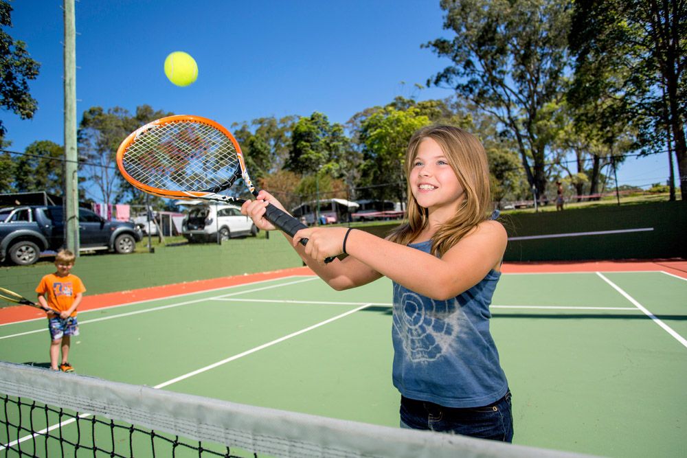 Children playing tennis on a court in a NSW park
