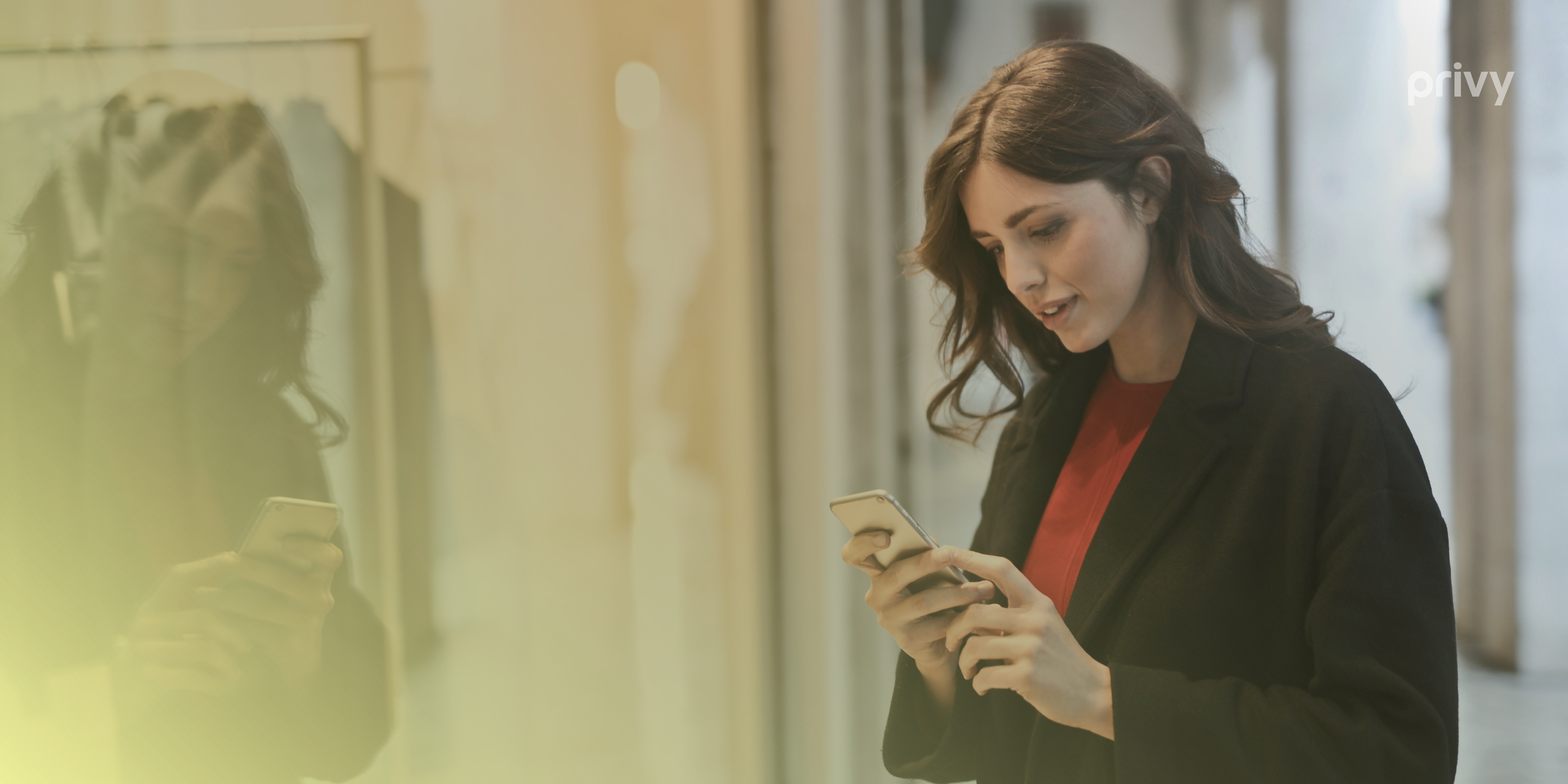 A woman in a black coat staring at a mobile device